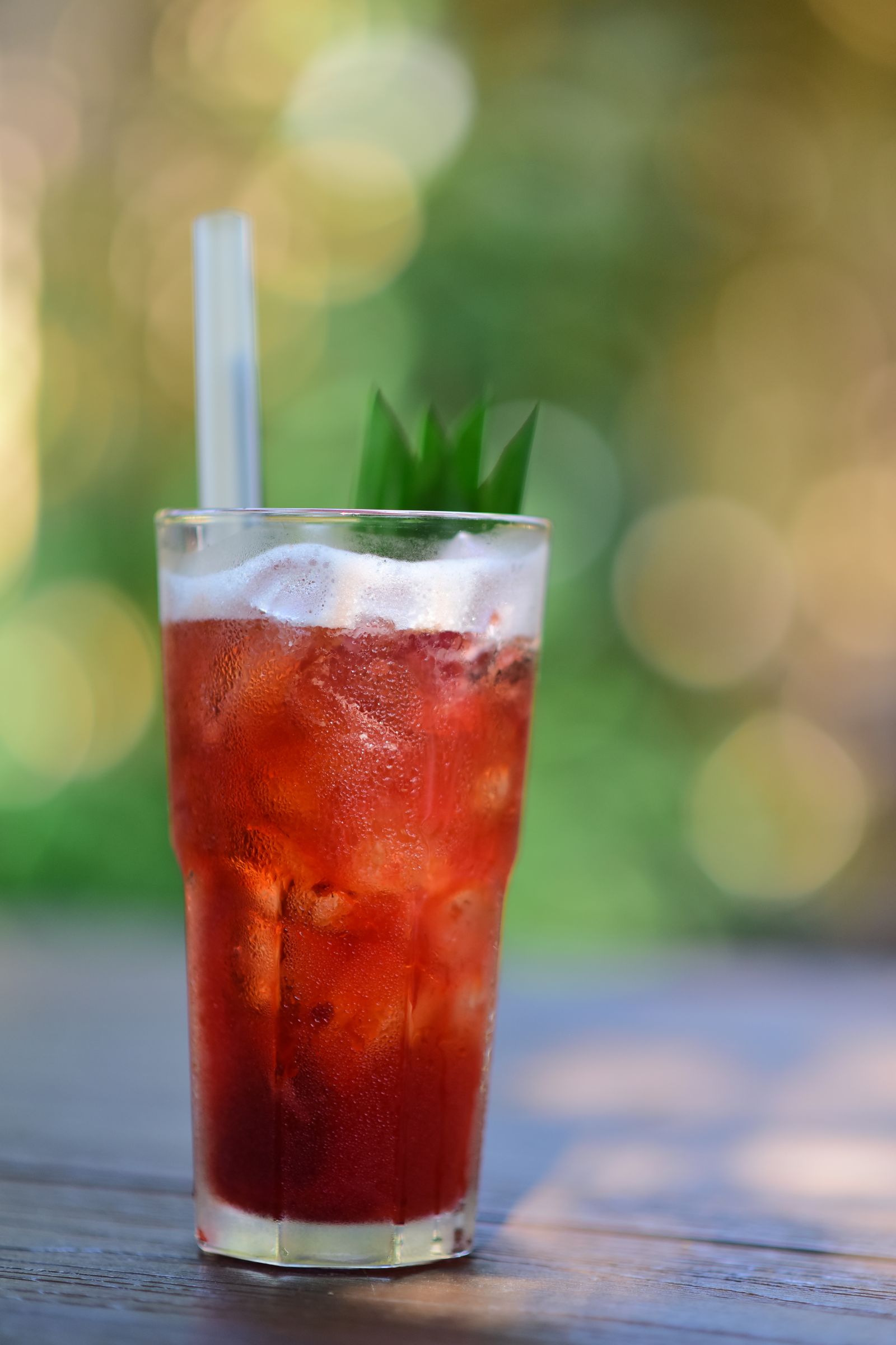 Tall glass of iced red fruit tea outdoors in warm sunlight (placeholder — awaiting client photos)
