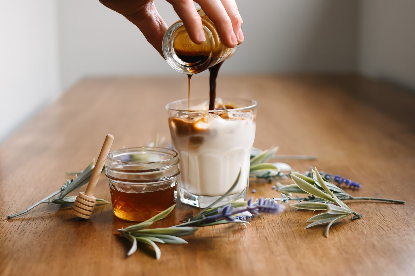 Honey being poured into a glass of iced coffee with milk (placeholder — awaiting client photos)
