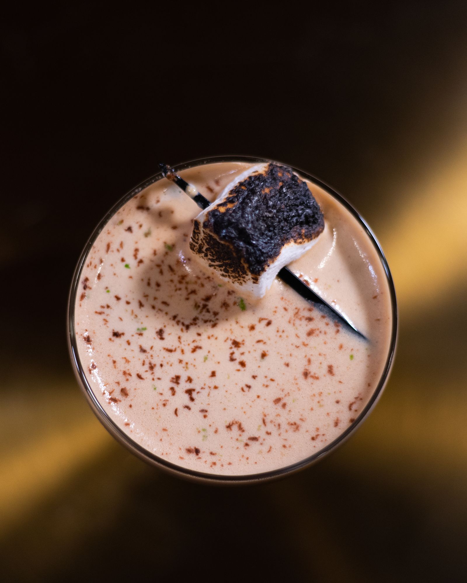 Overhead view of a creamy coffee drink topped with a charred, torched marshmallow (placeholder — awaiting client photos)
