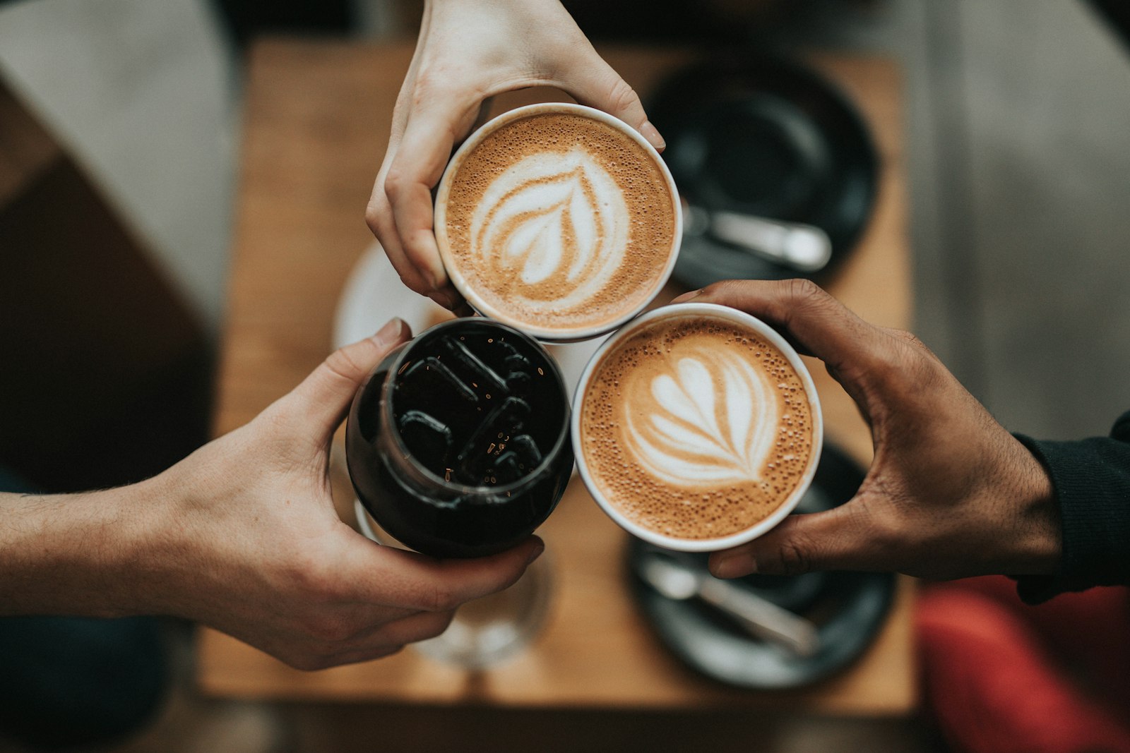 Coffee cups with latte art held together overhead (placeholder — awaiting client photos)