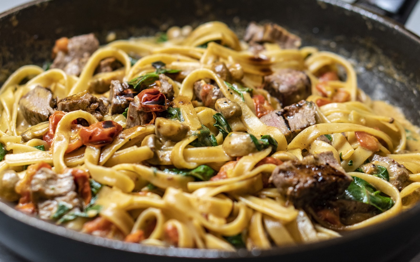 Pasta dish being prepared in the kitchen (placeholder — awaiting client photos)
