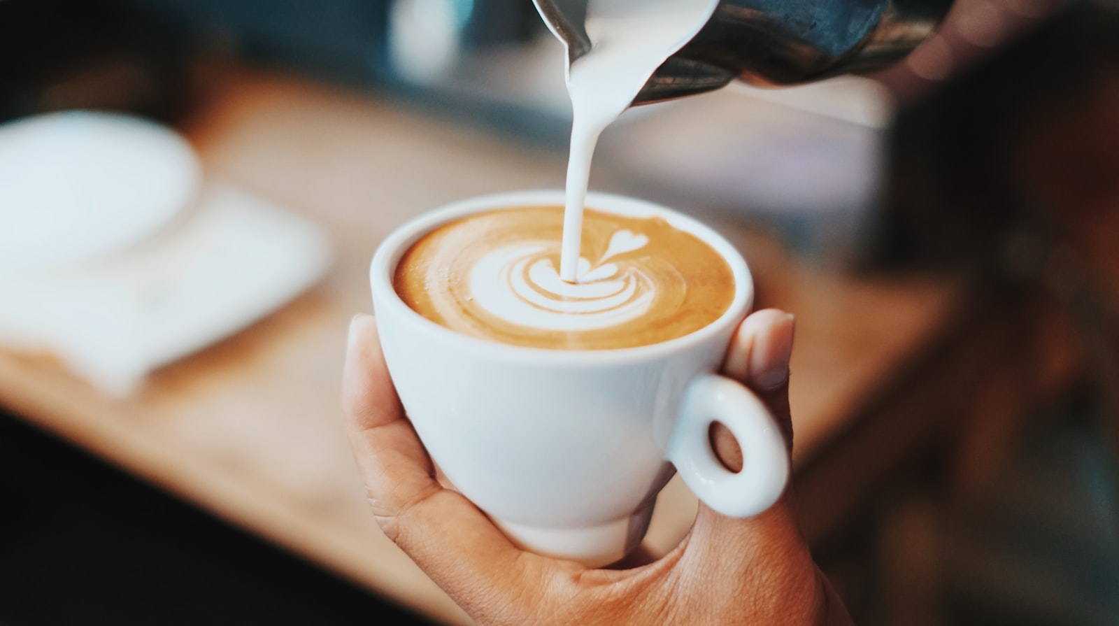 Barista pouring latte art into a ceramic cup (placeholder — awaiting client photos)